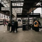 Travelers at ticket machines inside São Bento Railway Station, Porto.