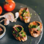 Mouth-watering bruschetta topped with anchovies and fresh herbs, paired with tomatoes and garlic.