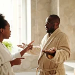 A couple in bathrobes having a discussion in a bathroom setting, expressing emotions.