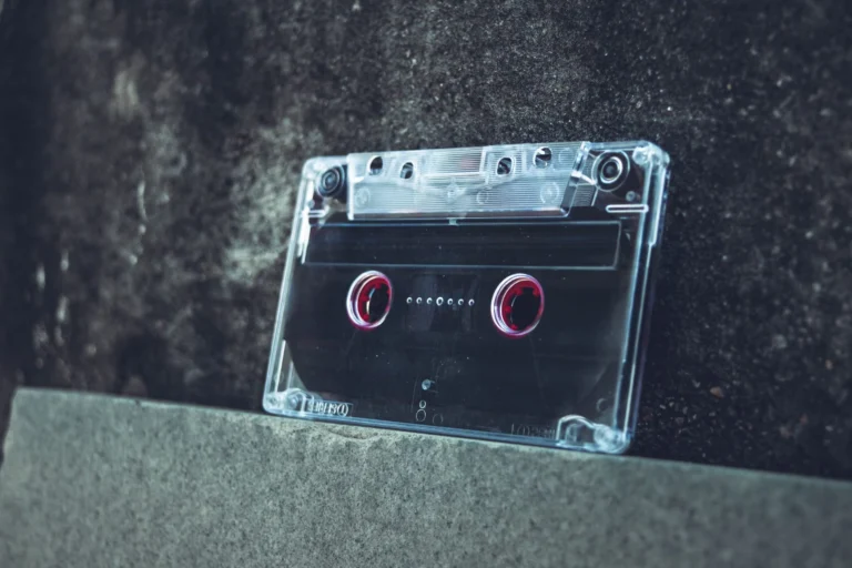 A clear cassette tape resting on a concrete surface evokes a vintage and nostalgic vibe.