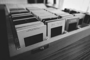 Black and white photo of vintage photography slides organized in a wooden box.