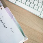 A close-up shot of a planner and keyboard on a desk, showcasing organization.
