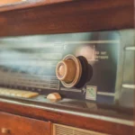 Close-up of a vintage radio showcasing its knobs and dial, reflecting retro style.