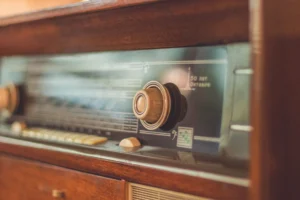 Close-up of a vintage radio showcasing its knobs and dial, reflecting retro style.