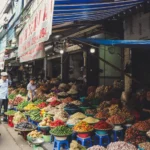 Bustling outdoor street market in Hanoi featuring colorful produce and local vendors.