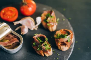 Mouth-watering bruschetta topped with anchovies and fresh herbs, paired with tomatoes and garlic.