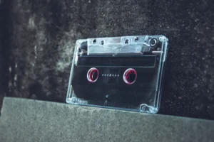 A clear cassette tape resting on a concrete surface evokes a vintage and nostalgic vibe.