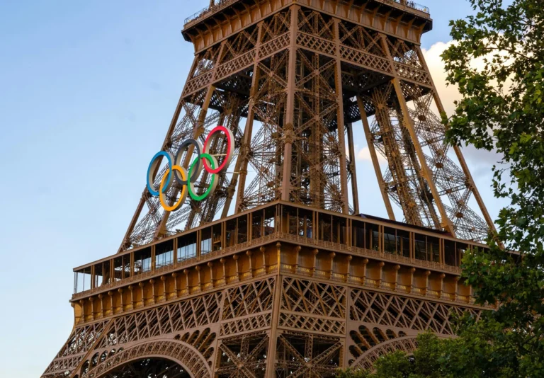 Close-up of Eiffel Tower featuring Olympic Rings during sunset in Paris.
