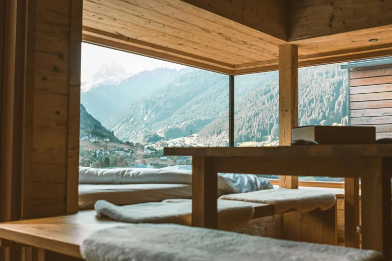 Warm wooden interior with mountain views through large glass windows creating a peaceful ambiance.