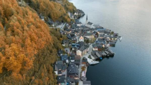 An aerial shot of Hallstatt, Austria surrounded by autumn foliage and lake views.