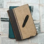 A classic setup with vintage books and a black feather on aged paper, perfect for historical or educational themes.