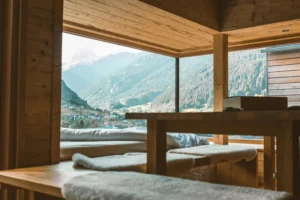 Warm wooden interior with mountain views through large glass windows creating a peaceful ambiance.