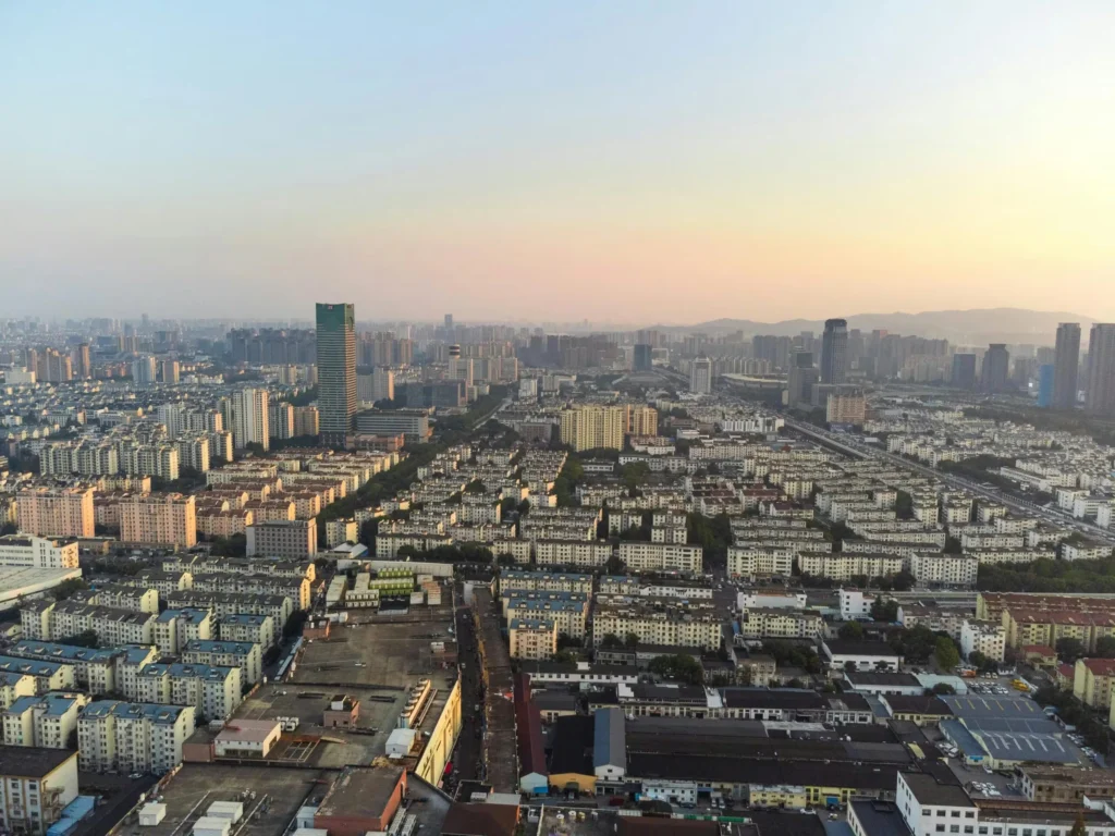 Aerial view of Suzhou's urban skyline at dusk showcasing modern architecture and sprawling cityscape.