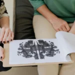A close-up of a Rorschach inkblot test during a psychotherapy session, highlighting mental health care.