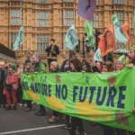 Protesters in London hold a banner advocating for environmental conservation. City streets echo with calls for action.