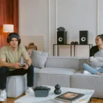 A couple enjoys gaming and relaxation in a stylish living room setting.