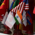 Colorful display of multiple national flags on stands, showcasing international diversity.