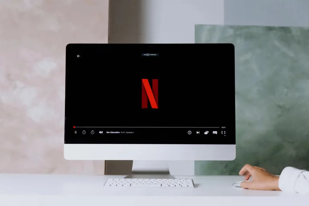 A minimalist workspace scene featuring a desktop displaying a streaming service, ideal for modern lifestyle themes.