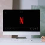 A minimalist workspace scene featuring a desktop displaying a streaming service, ideal for modern lifestyle themes.