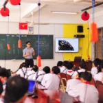 Teacher conducts an interactive lesson in a vibrant classroom setting with attentive students.