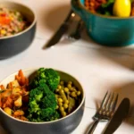Delicious colorful bowls of salad and fresh beverages on a white table, perfect for healthy dining.