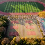Aerial photograph of a football and tennis court in Nanjing, China during autumn.