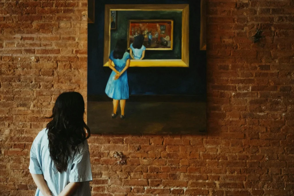 A woman admiring a painting in an art gallery, featuring a rustic brick wall.