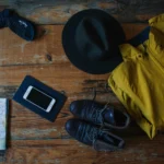 A flatlay of travel essentials on a rustic wooden table, ideal for adventurers.