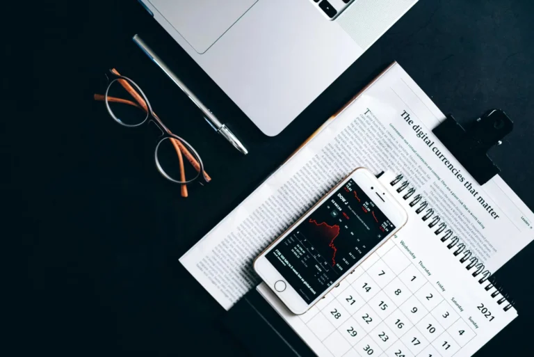 Flat lay of electronic devices and financial documents showcasing digital currency analysis.
