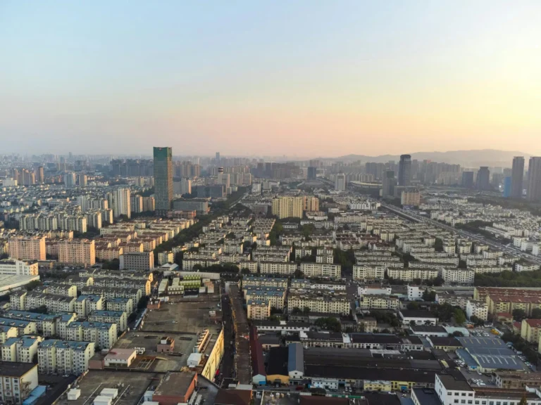Aerial view of Suzhou's urban skyline at dusk showcasing modern architecture and sprawling cityscape.