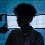 Artistic photo of a child's silhouette framed by digital tablets showing static, exploring technology and isolation.