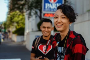 Two friends smiling while enjoying a sunny day on the street, capturing joy and friendship.
