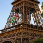 Close-up of Eiffel Tower featuring Olympic Rings during sunset in Paris.