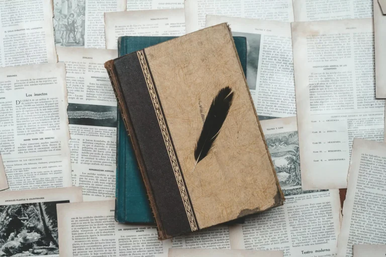 A classic setup with vintage books and a black feather on aged paper, perfect for historical or educational themes.