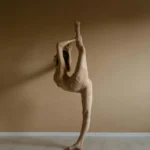 A graceful ballerina practicing an impressive ballet stretch indoors. Perfect for fitness and dance themes.