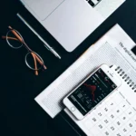 Flat lay of electronic devices and financial documents showcasing digital currency analysis.