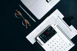 Flat lay of electronic devices and financial documents showcasing digital currency analysis.