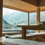 Warm wooden interior with mountain views through large glass windows creating a peaceful ambiance.