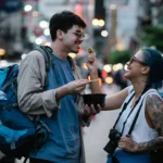 A couple enjoying street food in a lively city scene, capturing moments of joy and adventure.