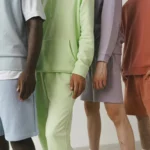 A close-up image showcasing a variety of pastel-colored men's fashion sweatshirts and shorts.
